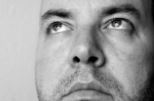 Photo of a man's face in black-and-white with his nose at center